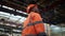 Cheerful supervisor looking camera at modern huge industrial facility warehouse.