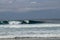 Cheerful Surfer Riding Big Foaming Ocean Wave in Sunny Nature. Man surfing on a cool surfboard in the summer sun near the idyllic