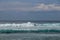 Cheerful Surfer Riding Big Foaming Ocean Wave in Sunny Nature. Man surfing on a cool surfboard in the summer sun near the idyllic