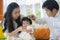 Cheerful and sweet wife and husband couple with mother holding baby girl and man playing with little daughter in Asian Chinese