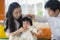 Cheerful and sweet wife and husband couple with mother holding baby girl and man playing with little daughter in Asian Korean