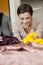 Cheerful Tailor Looking At Fabric While Leaning On Workbench