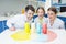 Cheerful teachers and girl student scientists making experiment in lab