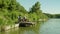 Cheerful teenage son and African American father relaxing on jetty on lake