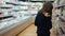 Cheerful teenager in the supermarket, taking sweets from the shelf