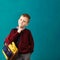 Cheerful thoughtful little school boy in school uniform with big