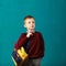 Cheerful thoughtful little school boy in school uniform with big