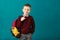 Cheerful thoughtful little school boy in school uniform with big