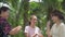 Cheerful three Thai adorable teen girls in casual dress enjoy to play together while standing in the park. Asian siblings.