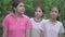 Cheerful three Thai teen girls in casual dress enjoy walking together among natural field in the countryside.