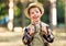 Cheerful tourist boy with backpack went hiking on summer day and smiles at camera