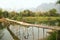 Cheerful Tourist crossing bamboo bridge, limestone view, laos