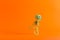 Cheerful toy skeleton dancing on orange background with copy space. Halloween party concept