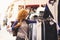 Cheerful traveler young blonde curly woman looking and choosing clothes at the used market during alternative vacation - shopping