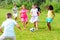 Cheerful tween friends playing with ball outdoors in summer