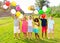 Cheerful tweenagers with colored balloons posing together in summer park