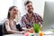 Cheerful two colleagues are using laptop for work