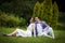 Cheerful valentine couple posing and sitting in park field