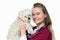 Cheerful veterinarian woman holding adorable puppy in vet clinic