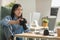 Cheerful Vietnamese Woman Photographer Holding Photocamera Sitting At Workplace
