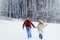 Cheerful walk of the beautiful smiling couple holding hands. Snowy forest location. Christmas time.