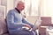 Cheerful white-haired pensioner working with new notebook