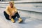 Cheerful woman in activewear resting on steps