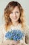 Cheerful woman with blue flowers. Natural beauty, skin without retouching