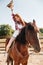 Cheerful woman cowgirl riding horse and having fun
