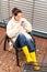 Cheerful woman drinking tea autumn rubber boots