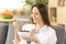 Cheerful woman eating cereals at home