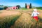 Cheerful woman enjoying the view in grain fields, Tuscany, Italy