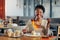 Cheerful woman enjoying yummy dessert and latte in cafeteria