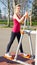 Cheerful woman in fitness wear exercising with equip