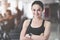 Cheerful woman folding arms in gym.