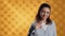 Cheerful woman happily doing salutation hand gesture, studio background