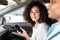 Cheerful Woman Holding Smartphone Sitting In Car In Passenger's Seat