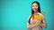 Cheerful woman holding Spanish flag book, education abroad, learning language