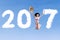 Cheerful woman leaping with 2017