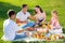 Cheerful woman picnicking with children and husband