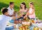 Cheerful woman picnicking with children and husband