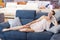 Cheerful woman with pillow on the sofa in furniture shop