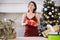 Cheerful woman poses against the background of a Christmas tree