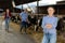 Cheerful woman posing in cowshed on farm breeding dairy cows