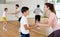 Cheerful woman practicing active dance in pair with tween son