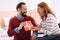 Cheerful woman receiving a gift from a beard man