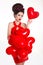 Cheerful woman in red dress with heart balloon, brunette mo