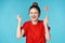 cheerful woman in a red t-shirt holding a lollipop blue background