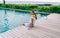 Cheerful woman resting on resort poolside and smiling