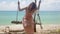 Cheerful woman riding self made swing on beach